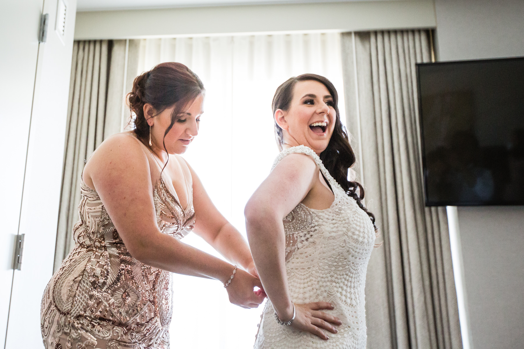 bridemaid zipping up wedding gown in Jersey City