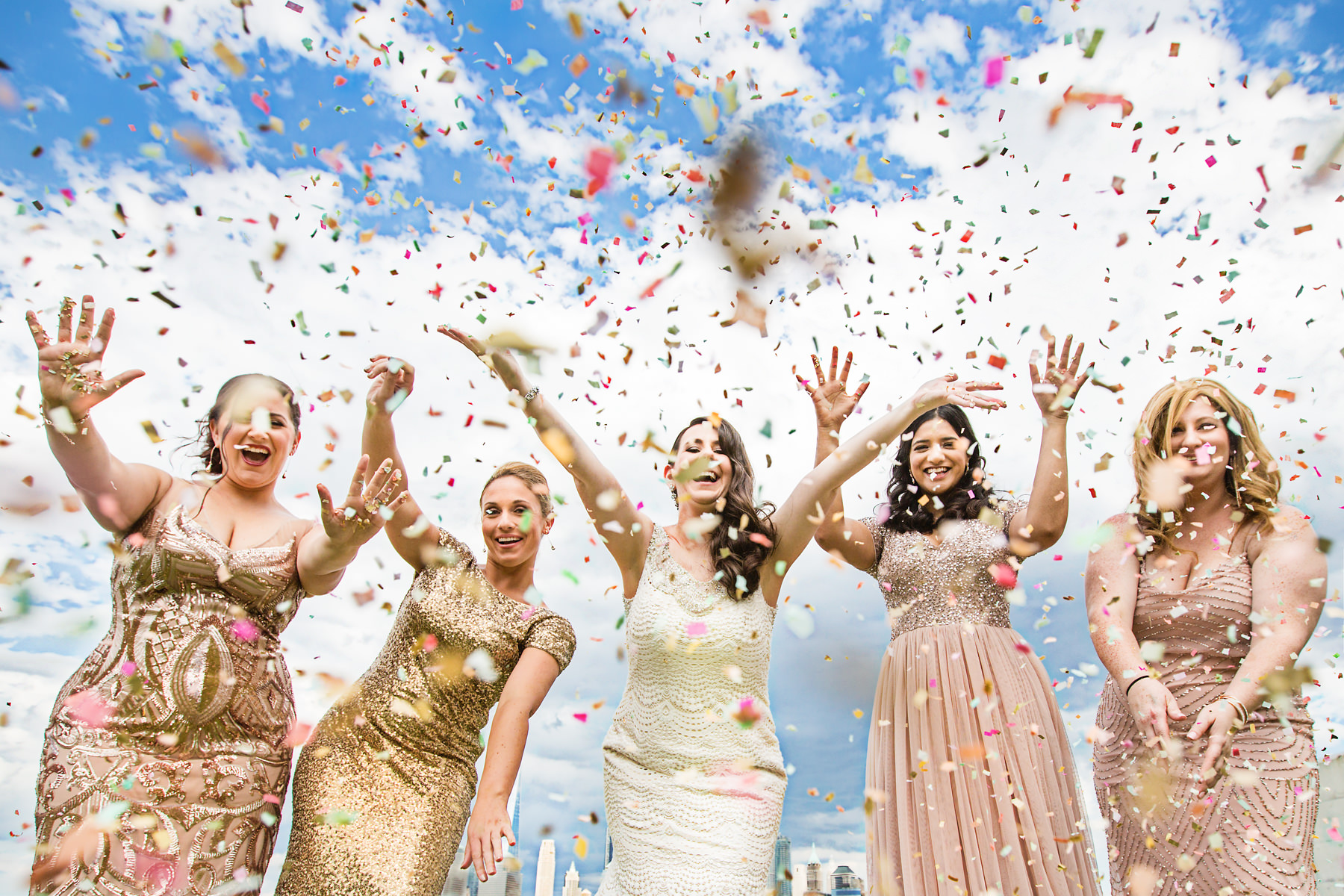 Bridesmaids and bride throwing confetti in Jersey City