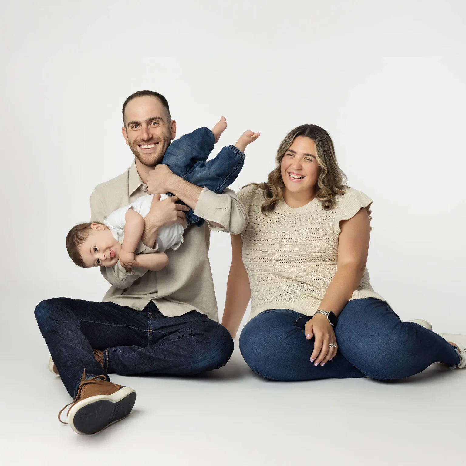 Studio family portrait of parents sitting together with their young child