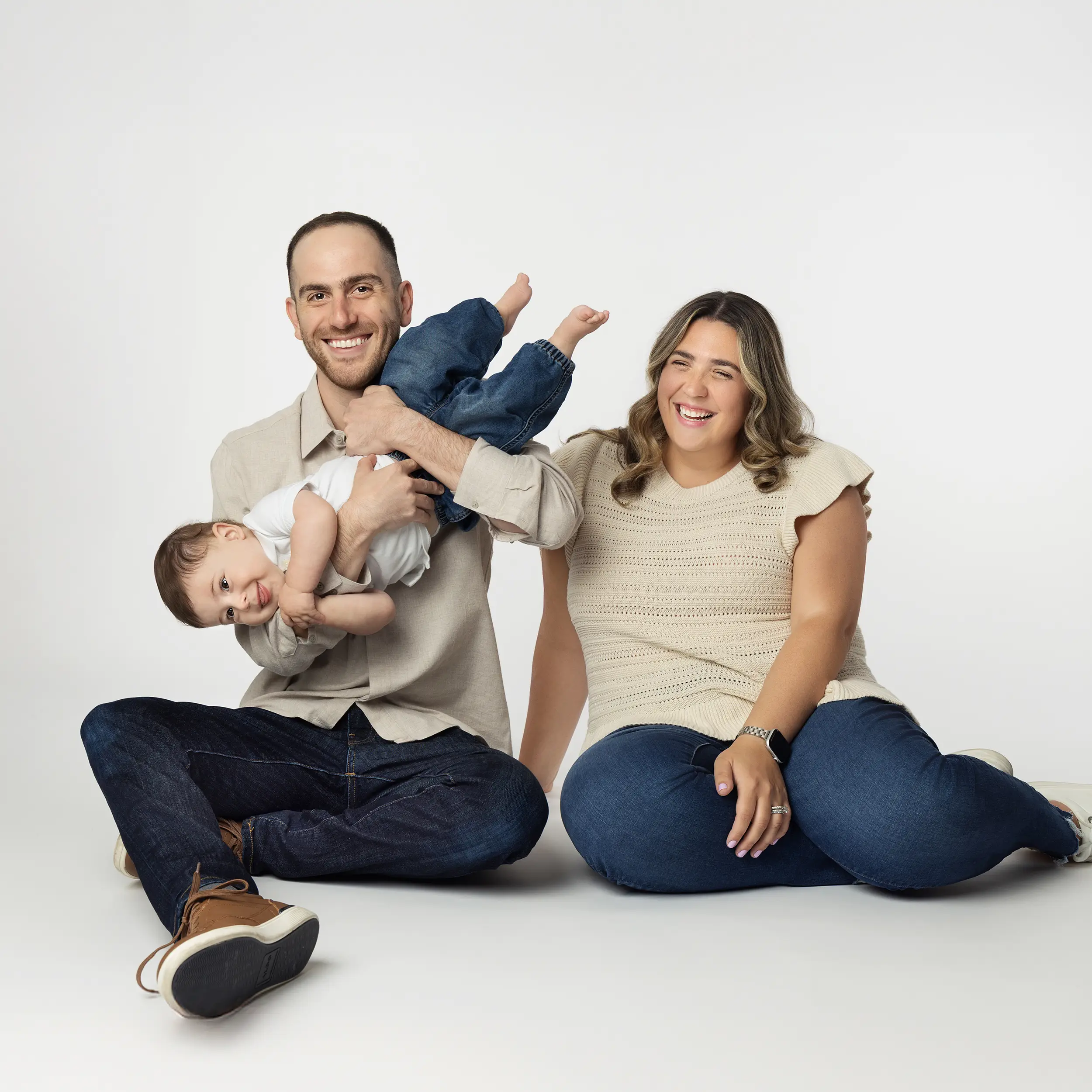 Studio family portrait of parents sitting together with their young child