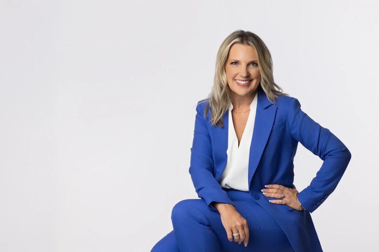 Portrait of a confident happy woman wearing a blue suite against a white background