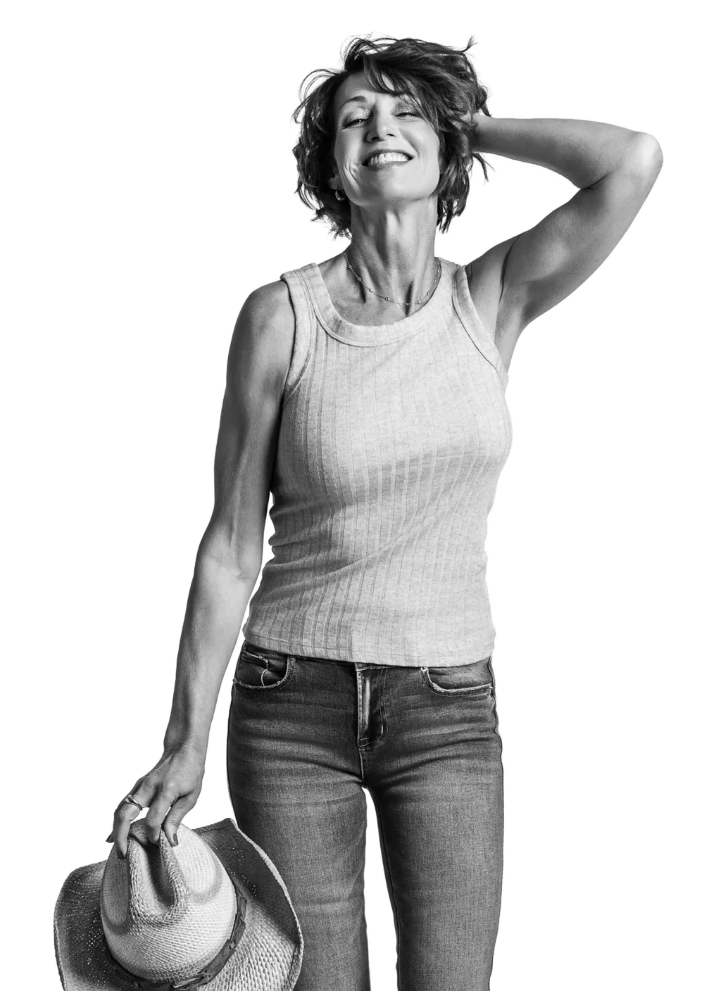 Black and white studio portrait of a woman smiling confidently against a white background.