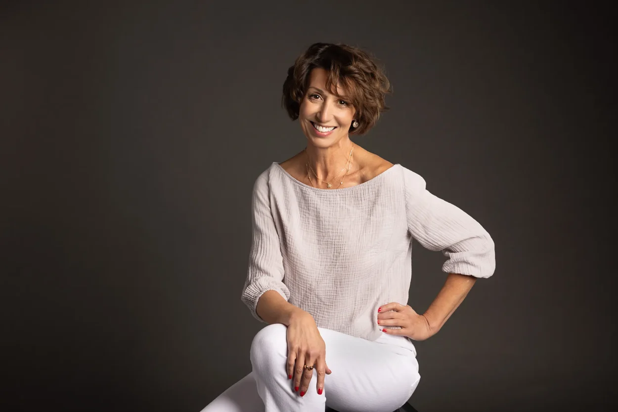 Professional studio headshot of woman seated and smiling